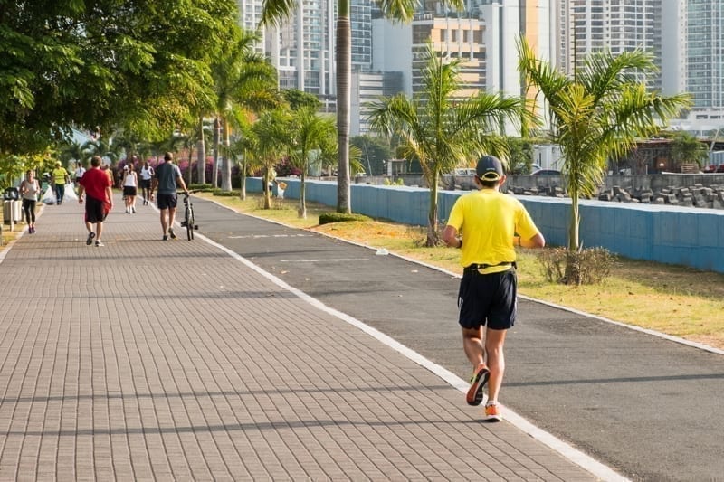 People running in public park with city skyline in background, Panama City, Panama