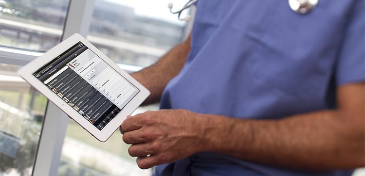 a doctor wearing scrubs holding a tablet