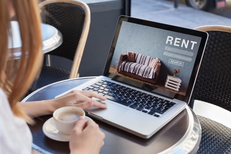 Woman using internet website to find rental apartments
