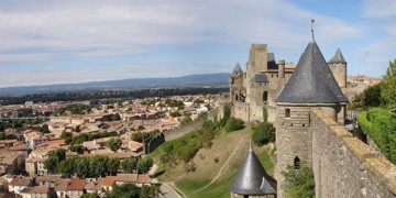 a stone wall and homes in carcassone france