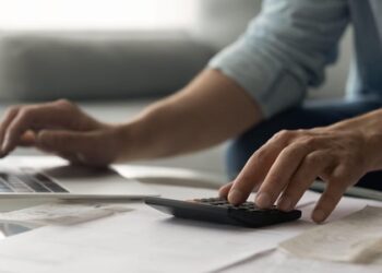 Man bookkeeper working with bills pay taxes online using laptop