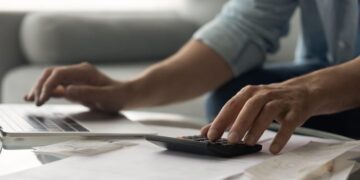 Man bookkeeper working with bills pay taxes online using laptop