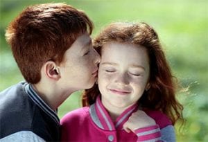 boy kissing a girl on the cheek