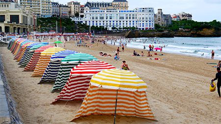 colorful striped tents lined up on the beach ready for beachgoers