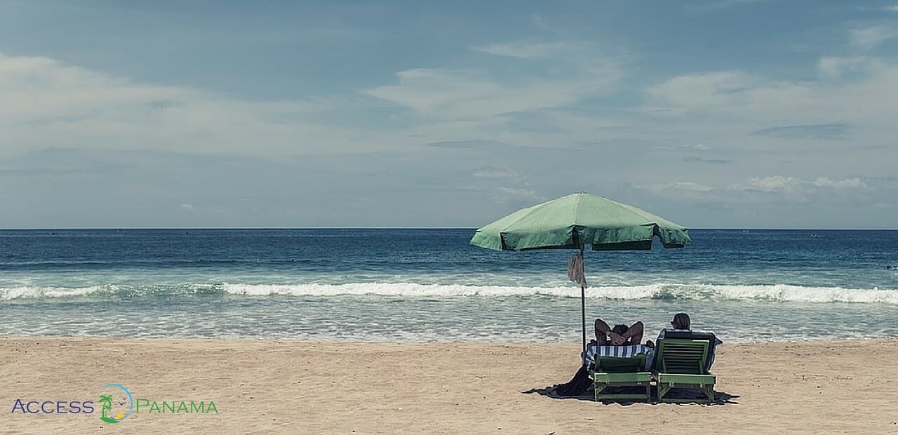 A Couple At The Beach Enjoying The Perks Of The Pensionado Discounts In Panama.