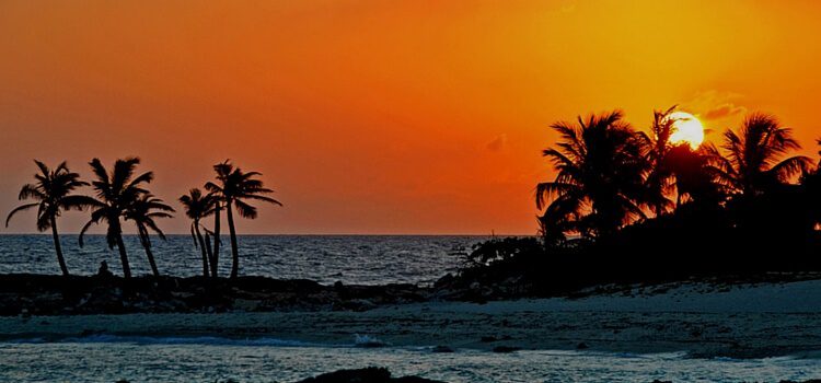 An ocean view of Mexico with the sun in the background.