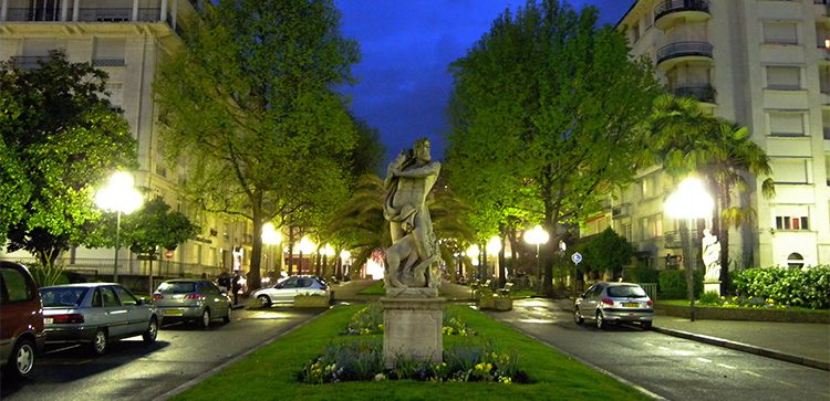 a night view of a statue in the median of Boulevard d'Aragon in Paris