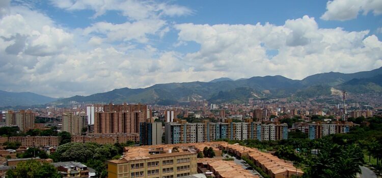 A view of big, white clouds and the brick covered buildings of Medellin, Colombia