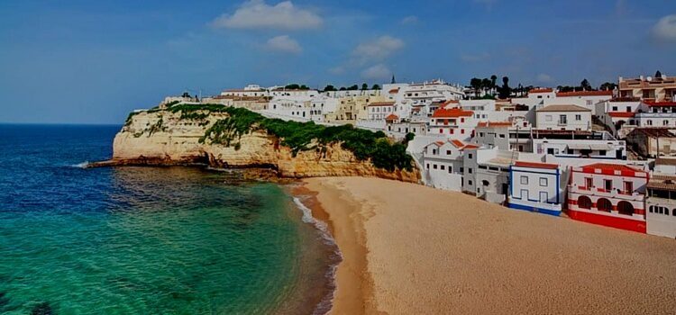 The Algarve Coast of Portugal complete with white houses that are trimmed with bright blues and reds