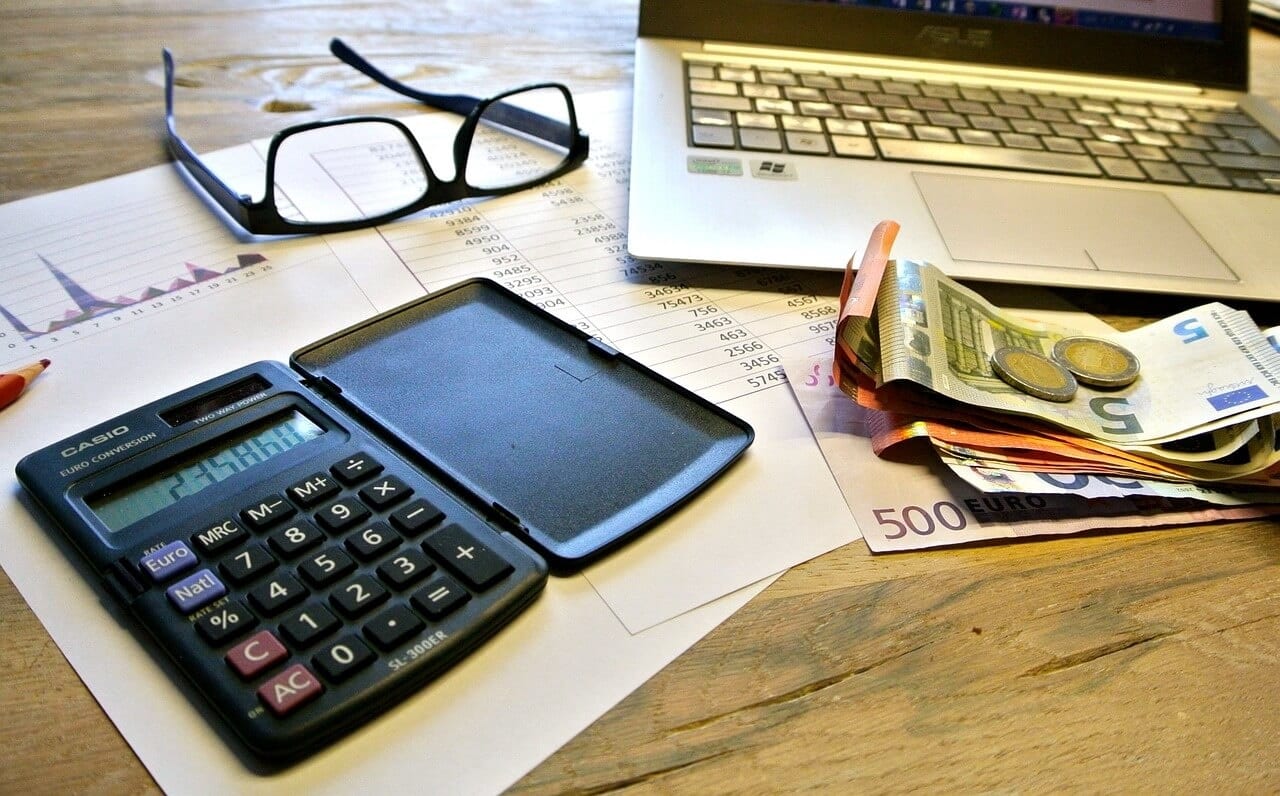 A table ready with calculator, a laptop, and everything needed to calculate the Foreign Earned Income Exclusion