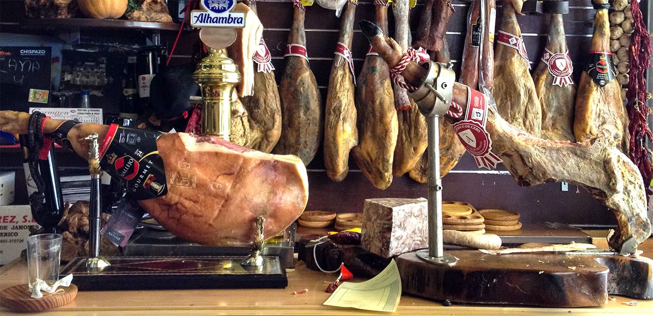 Cured ham hanging in a deli in Spain