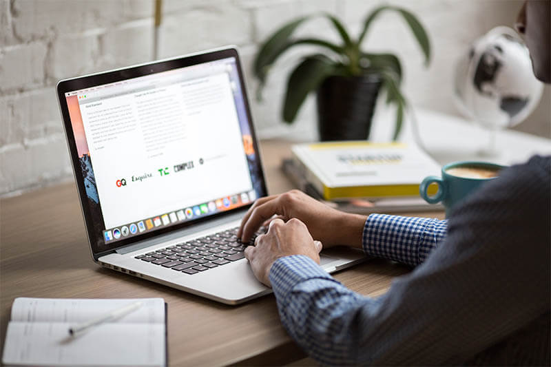 A man sitting down working on his laptop.