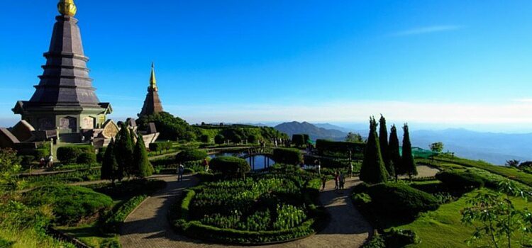 A mountain top view over Chiang Mai, Thailand with beautiful green gardens and a golden-topped temple