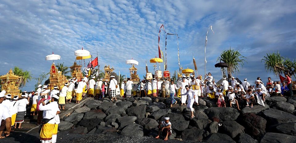 people celebrating a buddhist ceremony on a rock hill in Indonesia