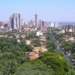 A view of Asuncion, Paraguay with plush green trees and a sprawling city in the background