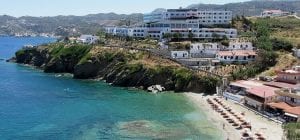 A seaside town on the island of Crete, complete with green and blue water.