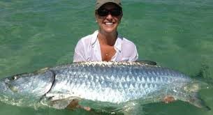 A smiling woman holding a tarpon