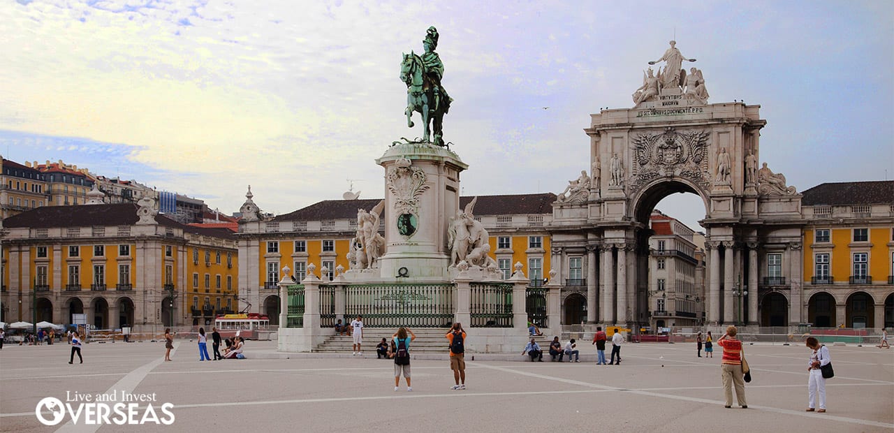 people walking around the plaza do comercio in lisbon