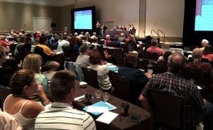 a panel of expertas in front of a full room of conference attendees