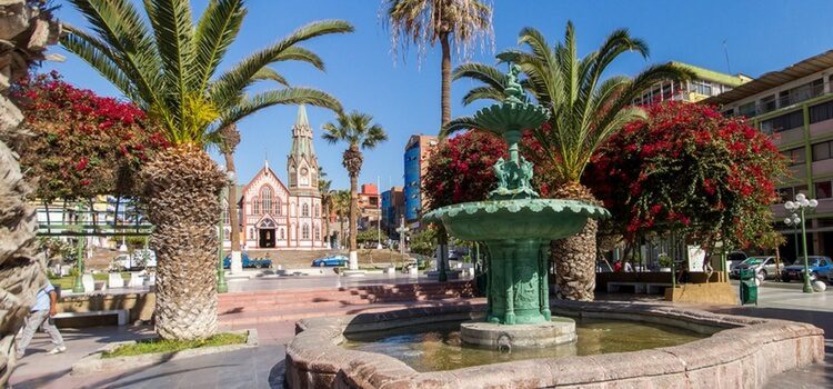 a plaza with plants and a fountain in Arica, Chile