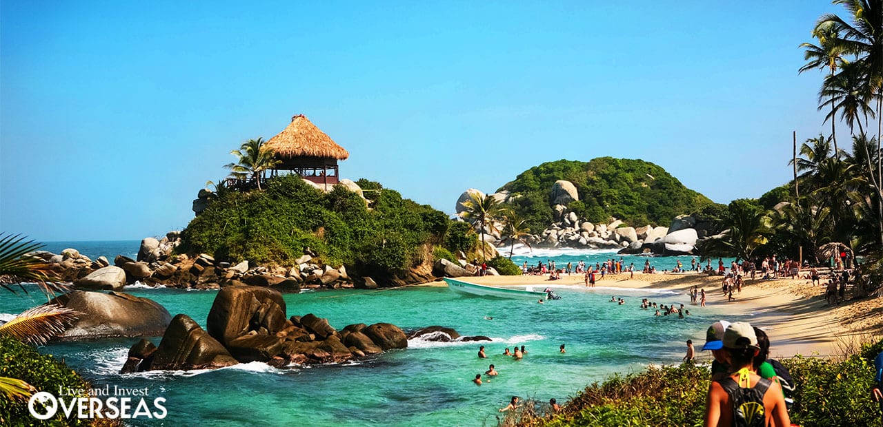 a popular beach with rocks and hills in colombia