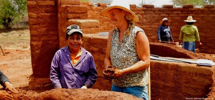 A couple of women working in Nicaragua building a wall from natural materials.