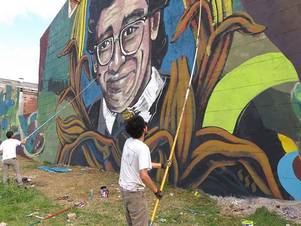 A man painting a mural in Colombia