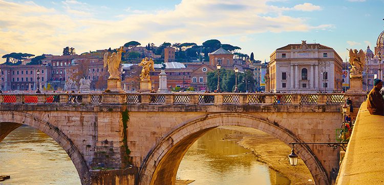 a bridge with angel statues with an old city in the background. retire in italy