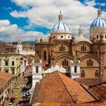 the colonial buildings and rooftops in cuenca on a sunny day