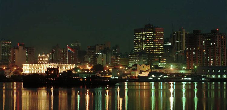 buildings at night by the water. cost of living in Paraguay