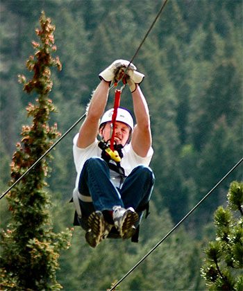 a man ziplining through trees