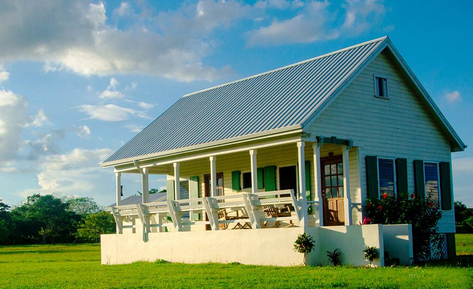 A cute white house with porch on a large plot of land