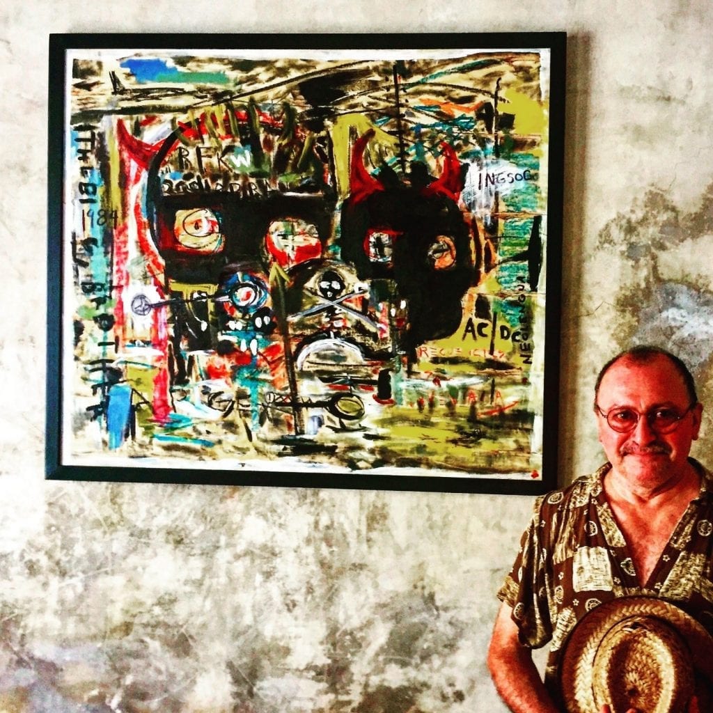Artist stands next to colorful abstract painting