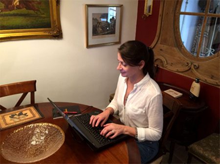 Kathleen sitting at a laptop in her paris apartment