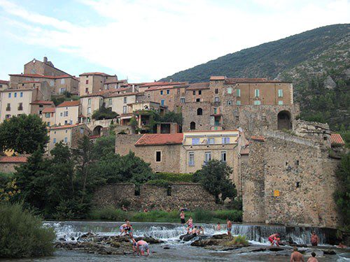 Stone buildings behind the river in Roquebron