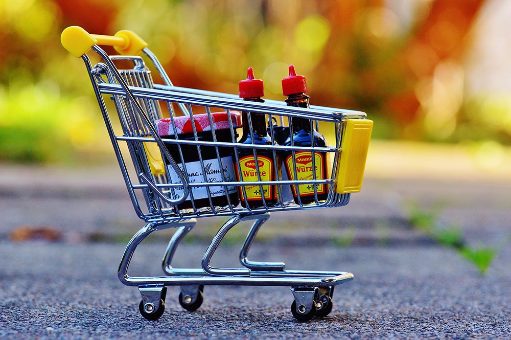 A tiny shopping cart with sauces and jam