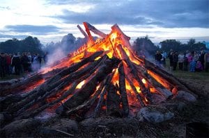 a bonfire burning in front of a crowd of people