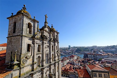 a beautiful old church and rooftops next to the ocean in Portugal
