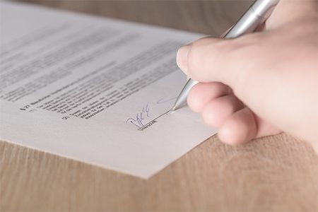 closeup of someone signing a contract