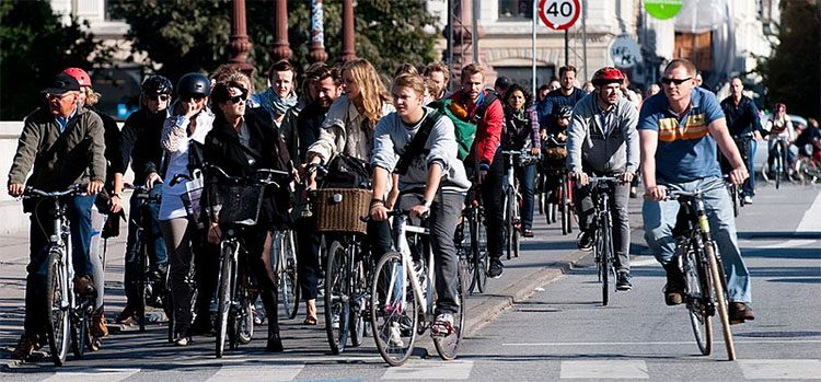 lots of people riding bicycles waiting at an intersection. travel europe budget