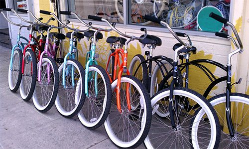 A row of colorful bicycles leaning on a storefront