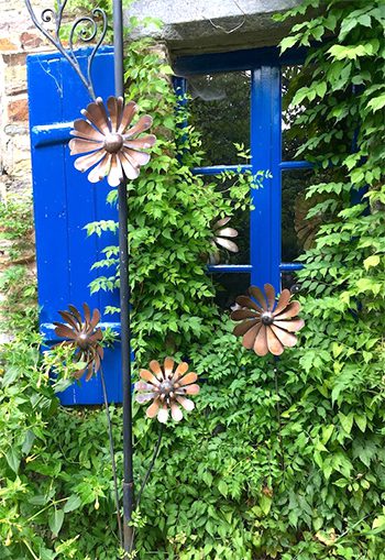 a window with blue shutters covered in wild ivy