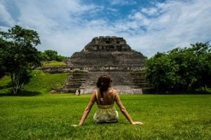 A woman sitting in front of Mayan ruins