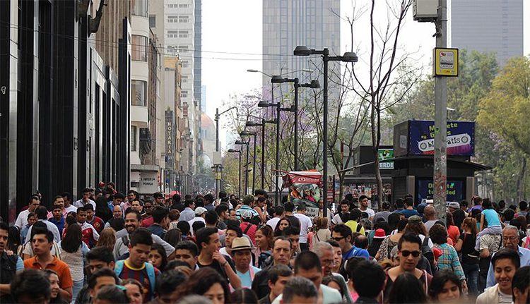 a crowd of people walking down the sidewalk