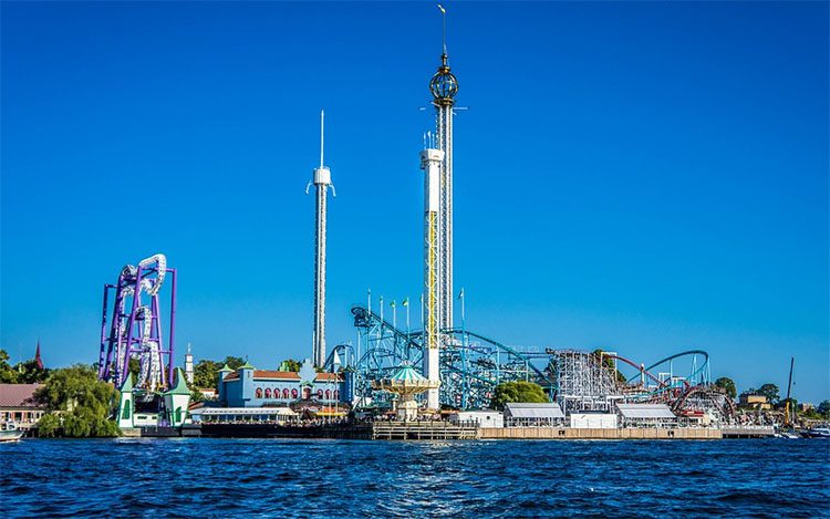 an amusement park with large roller coasters by the sea