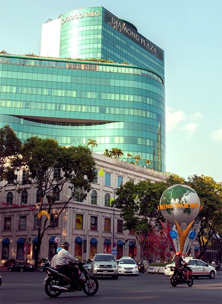 a large mall on a busy street corner in Vietnam