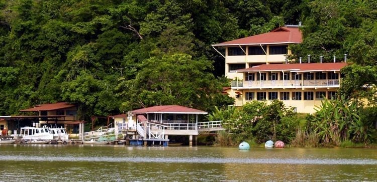 Buildings and dock on the water's edge in Barro Colorado Panama. Green rainforest in the back.