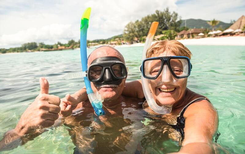 retired couple in sea with snorkelling masks