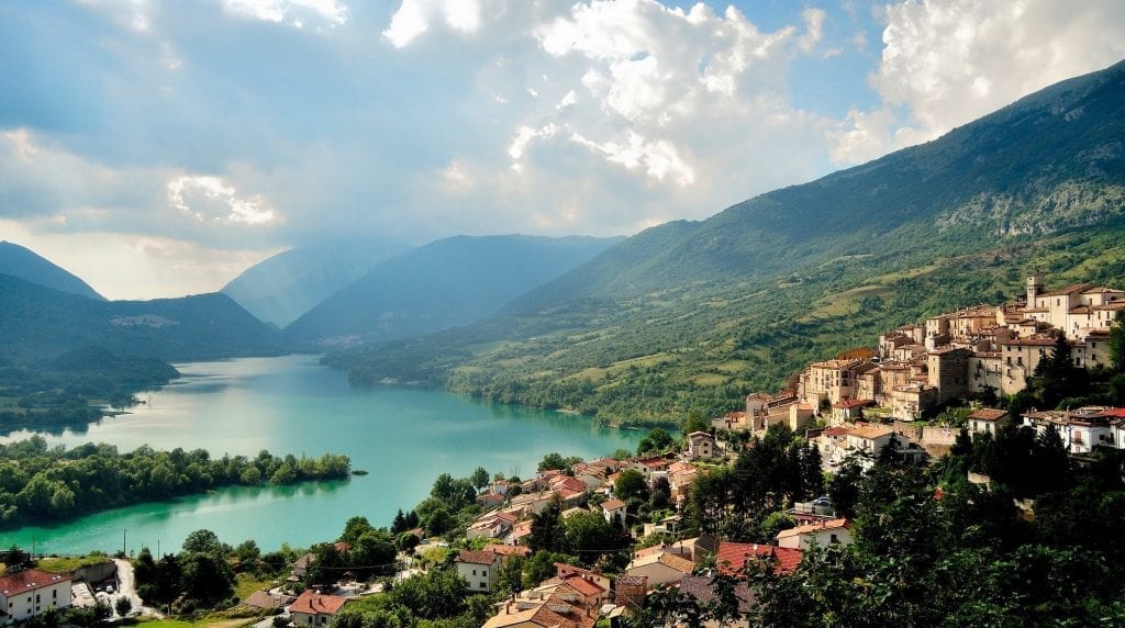 Aerial, long-distance view of a mountain valley village in Abruzzo, Italy