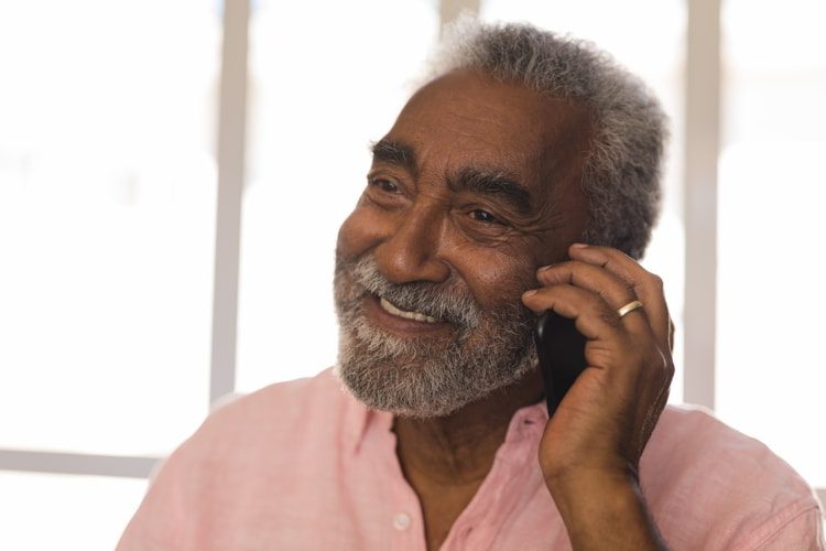 Senior man talking on mobile phone at home